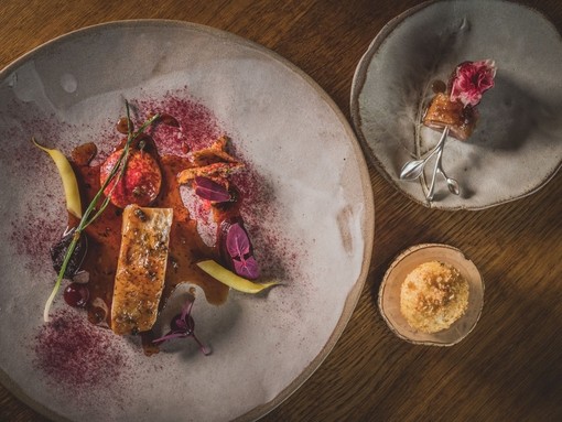 Three different sized plates of colourful food served on rustic grey crockery
