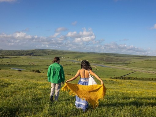 A man and a woman walk in the countryside in the summer
