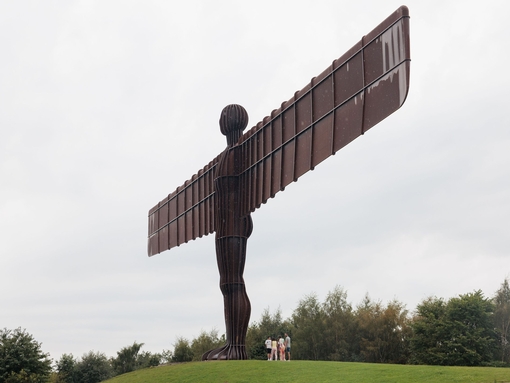 A family group visits the Angel of the North statue near Newcastle upon Tyne.