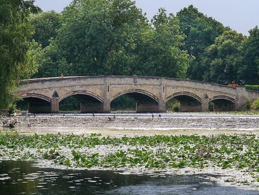 People walking across a bridge in Abbey Park, Leicester