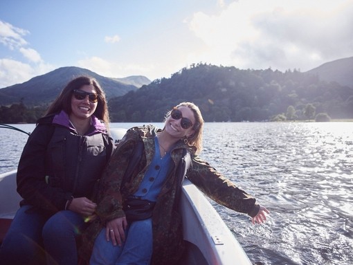 Two women wearing sunglasses on a boat on the lake