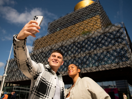 People posing for selfie in front of the Birmingham Library