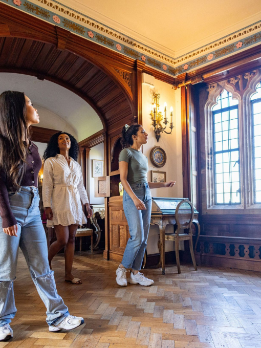 Three women exploring rooms in a castle