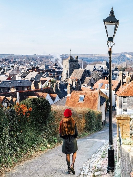 Girl looking down a countryside road to a village below