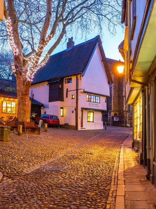A pretty village square with cobbled streets at dusk