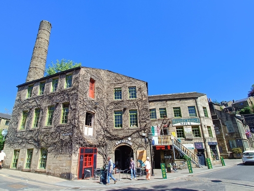 A village mill with passing pedestrians in the centre of an historic country village