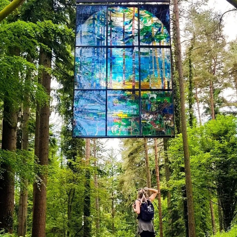 Large hanging stained glass window artwork of trees"Cathedral" by Kevin Atherton in The Forest of Dean